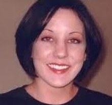 A Caucasian woman with short, dark, styled hair smiles at the camera.