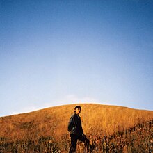 A photo of Burton standing in a field of tall grass