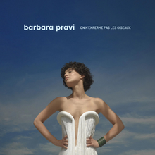 Photo taken in Italy, in June 2021, Barbara is elegantly dressed in a white dress, and has the title ‘On n’enferme pas les oiseaux’ at the top of the cover.