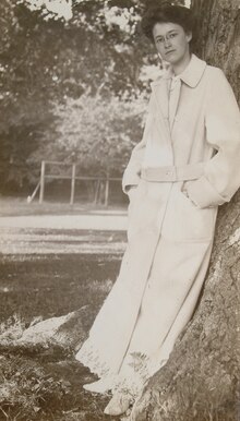 A picture of Theodora McCormick Du Bois standing against a tree.