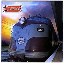 A train is alongside its platform, the engine dominates the central area. The band name is displayed in the upper left, while the album name is included on the engine to the viewer's front right. Beyond the train to the left appears a setting sun of orange to yellow light.