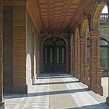 A photo of a walkway next to a building, surrounded by arches