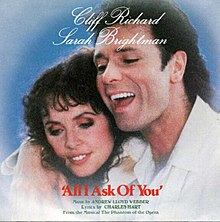 A photograph displaying Cliff Richard laying his right arm over the shoulder of Sarah Brightman.