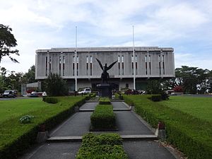 A concrete building is seen behind a statue