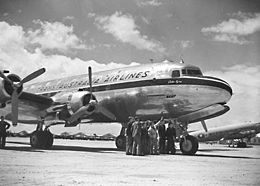 Kvarmotora burĝa kursa aviadilo sur flughaveno, portante la legendon "Trans Australia Airlines"