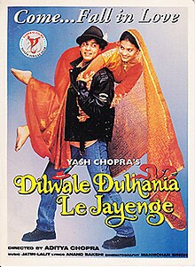 The Dilwale Dulhania Le Jayenge theatrical release poster shows a man in a black leather jacket and blue jeans holding over his shoulders a woman in a red wedding dress. A caption on top reads "Come ... Fall in Love".