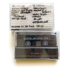 Photo of the front and back sides of two of the demo tape's cassettes against a white background.