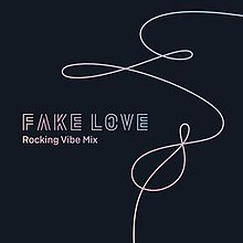 A white string-like design covering the majority of the right side of a dark blue square. The words "Fake Love" are written in all caps on the left side of the design inside the square. "Rocking Vibe Mix" is written just below it.