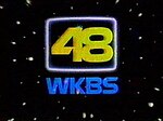 A yellow numeral 48 with futuristic elements inside a television screen-shaped outline with the blue letters W K B S in the same typeface below