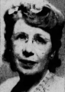 A middle-aged white woman, wearing eyeglasses