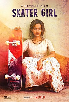 A girl in a dress, crouched and holding a skateboard upright.