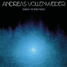 Photograph of reflected moon on the dark blue surface of water. Upper rim inscription, thin white letters reads : Andreas Vollenweider, Down to the Moon