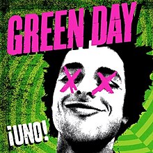 A black-and-white cutout of Billie Joe Armstrong's head, with his eyes crossed-out with pink X's, on a geometric, neon electric green background. The word "Green Day" is loudly splashed in pink across the top of the cover, while the word "¡Uno!" is sprawled graffiti-style in white in the lower left-hand corner.