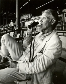 A man sitting in the stands at a horse racing track
