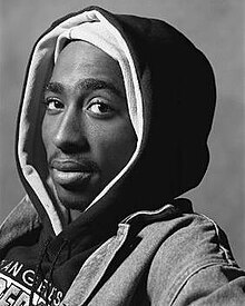 A black and white photo of Tupac Shakur staring at the viewer