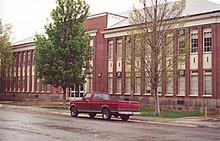 Photo of old Hurricane High School building with a red truck parked in front of it before its demolition in spring 2004.