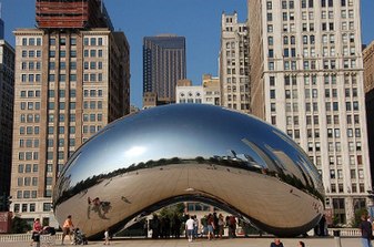A large, highly-polished, mirrored bean-shaped sculpture seen from the east, reflecting the skyscrapers to the north along East Randolph Street (The Heritage, Smurfit-Stone Building, Two Prudential Plaza, One Prudential Plaza, and Aon Center.