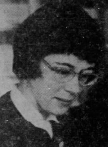 A white woman wearing short hair and glasses, looking downward; from a 1963 newspaper.