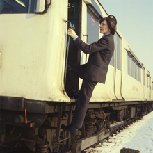 Women in traditional train driver's uniform boarding a white train