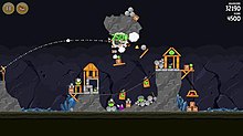 An in-game screenshot showing the yellow bird Chuck collapsing a structure onto several green pigs in the episode "Mine and Dine" Angry-Birds-in-Game-Play-1.jpg