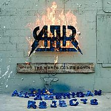 A photo of a sign burning with a wood on a wall in a white room. The band's name underneath is colored blue.