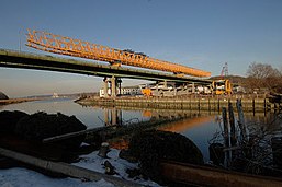 The original span of the William Cullen Bryant Bridge crossing Hempstead Harbor, looking northeast. Note the equipment used for constructing the replacement bridge, in addition to its prefabricated concrete segments.