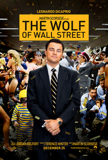 Leonardo DiCaprio on a tuxedo stands smiling, holding his hands together while it appears his office is either celebrating or going wild, or both. "The Wolf of Wall Street" (no quotes) is shown with black text on a yellow card above DiCaprio.