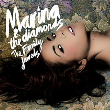 The face of a young brunette woman, lying sideways on a floral patterned background. In the top left corner of the image, the words "Marina and the Diamonds" and "The Family Jewels" are placed.