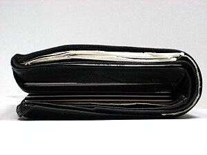 A single fold wallet filled with receipts, cas...