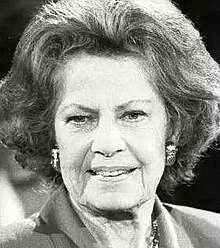 Smiling, elderly woman dressed smartly in the 1980s style (big hair and padded-shoulders)