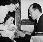 Jonas Salk administering the polio vaccine to a child