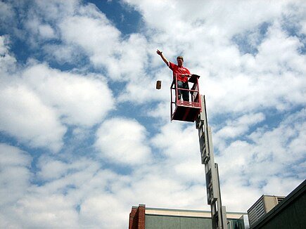 A physics teacher on a lift drops a package designed to protect three eggs from a fall of ten meters Eggdrop1.JPG