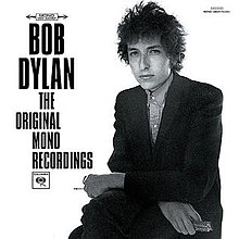 Черно-белая фотография Дилана, сидящего с руками на коленях.