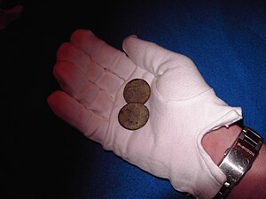 image of a curator holding ancient coins
