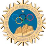 A stylized snowflake with the Olympic rings, a star and mountains. Surrounding the perimeter of the snow flake are the words, "VII Giochi Olimpici Dinverno, Cortina d'Ampezzo 1956"