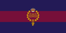 Image en couleurs d'un drapeau composé de trois bandes horizontales, les deux bandes extérieures bleues et la bande du centre violet et portant au centre un insigne militaire