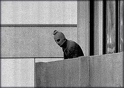 אחד מהמחבלים עומד על מרפסת הבניין שבו הוחזקו בני הערובה