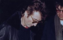 ג'ון לנון חותם על עותק של אלבומו החמישי של ג'ון Double Fantasy השייך לצ'פמן העומד מימינו. התמונה צולמה כמה שעות לפני שצ'פמן חזר וירה בלנון למוות