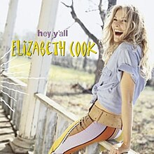 Portet wanita pirang tertawa sambil bersandar di susur sebuah teras, judul "Hey Y'all" dan nama "Elizabeth Cook" tertulis di sampingnya, masing-masing dalam warna ungu dan kuning.