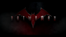 "BATWOMAN" written in a metallic font over a dark background with a red/orange bat symbol in the background