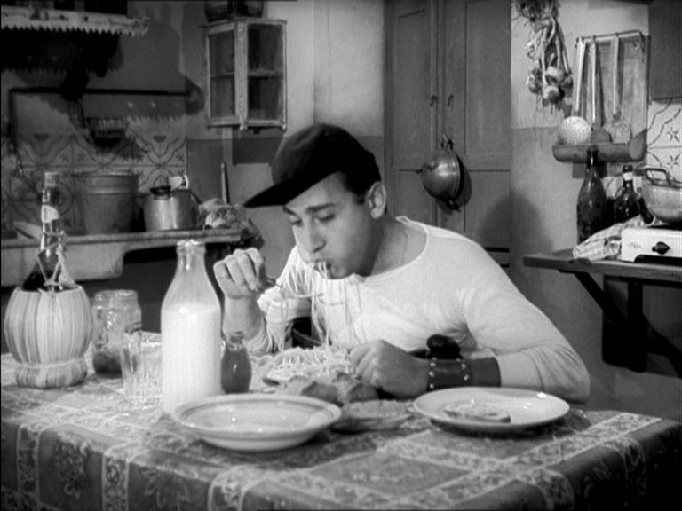 Un Americano a Roma (1954). Alberto Sordi representing what became an Italian post-war stereotype: pasta, Chianti and a busy kitchen, giving a wink to American culture (Sordi is eating spaghetti wearing a baseball cap)