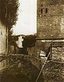 Fotografia di fine Ottocento che mostra come alla base della torre scorresse, allo scoperto, il canale Ravaldino. Nei decenni successivi il canale fu coperto