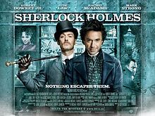 Robert Downey, Jr. dan Jude Law, dalam watak. Latar adalah paparan tingkap, menunjukkan para yang mengandungi pelbagai barangan yang berkait dengan cerita. Poster tertulis "Sherlock Holmes" sepanjang atas, dengan baris tag "Holmes for the holiday" tengan bahagian bawah. Poster ini kebanyakannya bewarna turquoise.