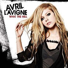 Mulher loira vestida em uma blusa preta com um decote translúcido que exibe seu sutiã e com um colar onde se encontra escrito "beba-me" (em inglês: "drink me"). No canto esquerdo superior da imagem, está escrito "Avril Lavigne" em preto e logo abaixo, "What the Hell" em vermelho.