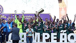 Jogadores erguendo o troféu em comemoração