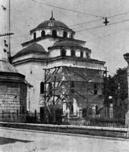 Јужна страна Ферхадије у скелама, 1953. год. На минарету и фасади џамије виде се оштећења од крхотина граната. Фучић наводи да су се оштећења поправила уметањем плоча од седре, а ако су ситна, пломбирањем китом од каменог брашна. Осим тога, нишани на гробљу, видљиви на слици, су очишћени од маховине и лишајева.[657][660]