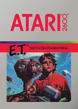 Artwork of a grey, vertical rectangular box. The top half reads "Atari 2600. E.T.* The Extra-Terrestrial". The bottom half displays a drawn image of a brown alien with a large head and long neck beside a young boy in a red, hooded jacket.