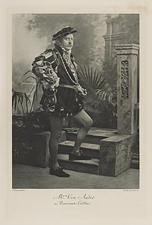 Black-and-white photograph of a man standing with one foot on a step richly dressed in an historical costume