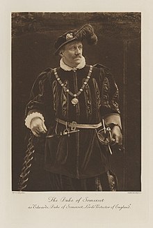 Black-and-white photograph of a standing man richly dressed in an historical costume