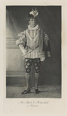 Black-and-white photograph of a standing man richly dressed in an historical costume